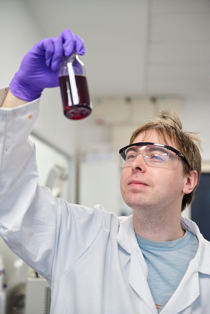 Man looking at test tube in Xampla lab at Cambridge Science Park