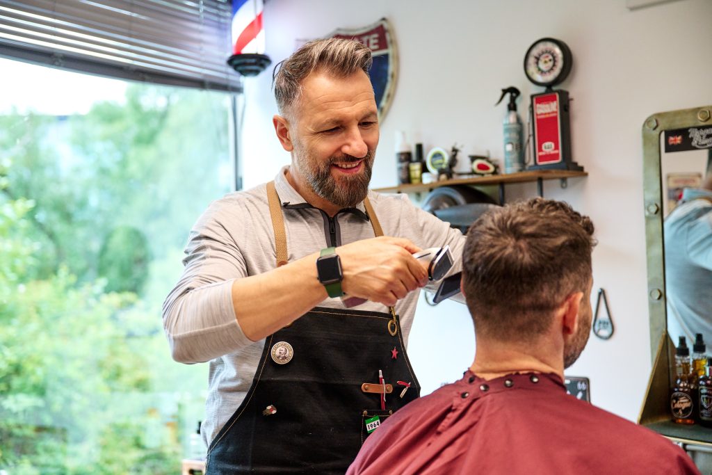 Barber cutting man's hair with clippers